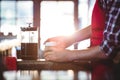 Mid section of waiter preparing coffee