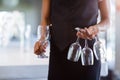 Mid section of waitress holding empty wine glasses