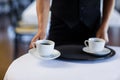 Mid section of waitress serving cup of coffee Royalty Free Stock Photo