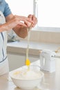 Mid section of woman cracking an egg in bowl at kitchen Royalty Free Stock Photo