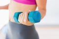 Mid section of a woman lifting dumbbell weight in gym Royalty Free Stock Photo