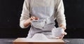 Woman sieving flour from the bowl on the wooden board 4k