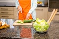 Mid section of woman slicing cucumber for salad Royalty Free Stock Photo