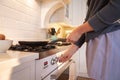 Mid section of woman switching on the gas stove