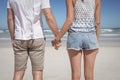 Mid section of young couple holding hands at beach Royalty Free Stock Photo