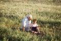 Mid shot of grandfather and his grandson while reading a book together in meadow Small boy making first steps in read