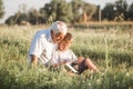 Mid shot of grandfather and his grandson while reading a book together in meadow Small boy making first steps in read