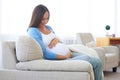 Happy pregnant woman resting at home on the sofa Royalty Free Stock Photo