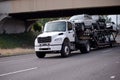 Mid size semi truck car hauler transporting vehicles on the road Royalty Free Stock Photo