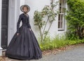 Victorian woman in summer garden standing by a house Royalty Free Stock Photo