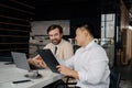 Midaged asian businessman showing documents to his smiling european partner Royalty Free Stock Photo