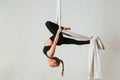 In the midair. Young beautiful woman doing fly yoga against white background