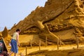 Middelkerke, Belgium - 23 July 2022: A person looking at a fallen pteranodon dinosaur sand sculpture in Middelkerke, Belgium. The