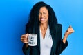 Middle age african american woman drinking from i am the boss coffee cup screaming proud, celebrating victory and success very