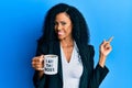 Middle age african american woman drinking from i am the boss coffee cup smiling happy pointing with hand and finger to the side Royalty Free Stock Photo