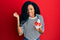 Middle age african american woman eating strawberry ice cream screaming proud, celebrating victory and success very excited with Royalty Free Stock Photo