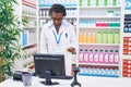 Middle age african american woman pharmacist smiling confident using computer at pharmacy Royalty Free Stock Photo