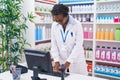 Middle age african american woman pharmacist using computer at pharmacy Royalty Free Stock Photo