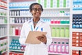 Middle age african american woman pharmacist writing on document at pharmacy Royalty Free Stock Photo