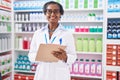 Middle age african american woman pharmacist writing on document at pharmacy Royalty Free Stock Photo
