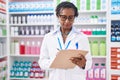 Middle age african american woman pharmacist writing on document at pharmacy Royalty Free Stock Photo