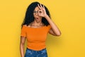 Middle age african american woman wearing casual clothes and glasses doing ok gesture shocked with surprised face, eye looking Royalty Free Stock Photo
