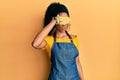 Middle age african american woman wearing professional apron covering eyes with hand, looking serious and sad Royalty Free Stock Photo