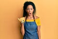Middle age african american woman wearing professional apron surprised pointing with hand finger to the side, open mouth amazed Royalty Free Stock Photo