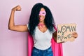 Middle age african american woman wearing super hero costume holding woman power banner smiling with a happy and cool smile on