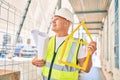 Middle age architect man holding blueprints and house project walking at the city Royalty Free Stock Photo