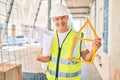 Middle age architect man holding blueprints and house project walking at the city Royalty Free Stock Photo