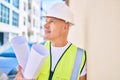 Middle age architect man holding blueprints leaning on the wall at the city Royalty Free Stock Photo