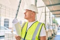 Middle age architect man holding blueprints walking at the city Royalty Free Stock Photo