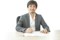 Middle age Asian businessman writing document report in the office. Signing contract. Royalty Free Stock Photo