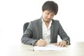 Middle age Asian businessman writing document report in the office. Signing contract. Royalty Free Stock Photo