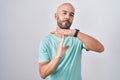 Middle age bald man standing over white background doing time out gesture with hands, frustrated and serious face Royalty Free Stock Photo