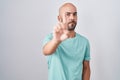 Middle age bald man standing over white background pointing with finger up and angry expression, showing no gesture Royalty Free Stock Photo
