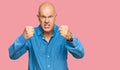 Middle age bald man wearing casual clothes angry and mad raising fists frustrated and furious while shouting with anger Royalty Free Stock Photo