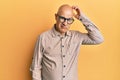 Middle age bald man wearing casual clothes and glasses confuse and wonder about question Royalty Free Stock Photo