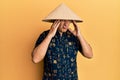 Middle age bald man wearing traditional asian straw hat with hand on head, headache because stress Royalty Free Stock Photo
