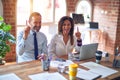 Middle age beautiful business workers working together using laptop at the office pointing finger up with successful idea Royalty Free Stock Photo