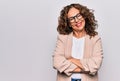 Middle age beautiful businesswoman wearing glasses standing over isolated white background happy face smiling with crossed arms Royalty Free Stock Photo