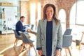 Middle age beautiful businesswoman wearing jacket and glasses standing at the office with a happy and cool smile on face Royalty Free Stock Photo