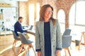 Middle age beautiful businesswoman wearing jacket and glasses standing at the office looking away to side with smile on face, Royalty Free Stock Photo