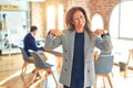 Middle age beautiful businesswoman wearing jacket and glasses standing at the office looking confident with smile on face, Royalty Free Stock Photo