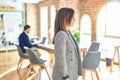 Middle age beautiful businesswoman wearing jacket and glasses standing at the office looking to side, relax profile pose with Royalty Free Stock Photo