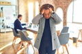 Middle age beautiful businesswoman wearing jacket and glasses standing at the office suffering from headache desperate and Royalty Free Stock Photo