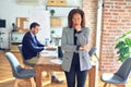 Middle age beautiful businesswoman wearing jacket and glasses standing at the office thinking looking tired and bored with Royalty Free Stock Photo