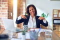 Middle age beautiful businesswoman working using laptop at the office looking confident with smile on face, pointing oneself with Royalty Free Stock Photo