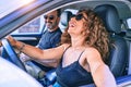 Middle age beautiful couple on vacation wearing sunglasses smiling happy driving car